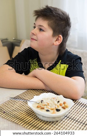 Teenager boy refuses to eat a oatmeal for breakfast