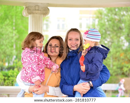 Two mothers with children on the walk in the gazebo