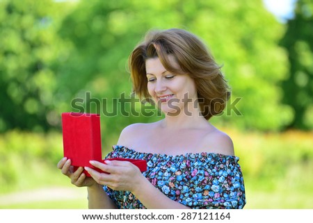 Cute woman with gift at a summer park