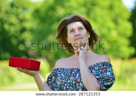 Cute woman with gift at a summer park