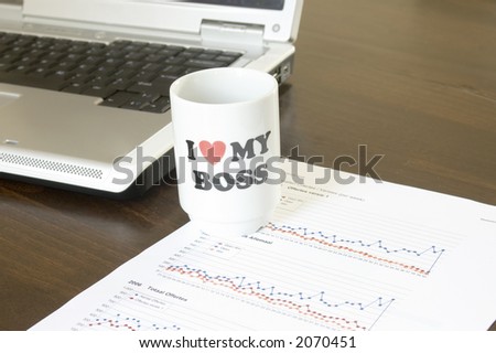 I love my boss coffee cup with laptop and charts on background
