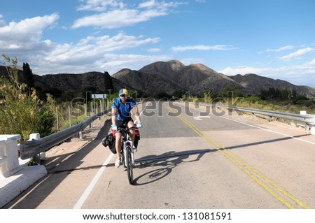 A cyclist with loaded bicycle touring North Argentina