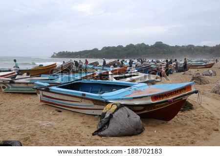ARUGAN BAY, SRI LANKA - JANUARY 12: Tamil men doing a traditional fishing on a beach January 12, 2014 in Arugan Bay ,Sri Lanka. This activity will provide a income stream for people.
