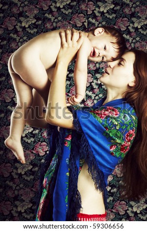 Young mother small child on hands studio photo shooting