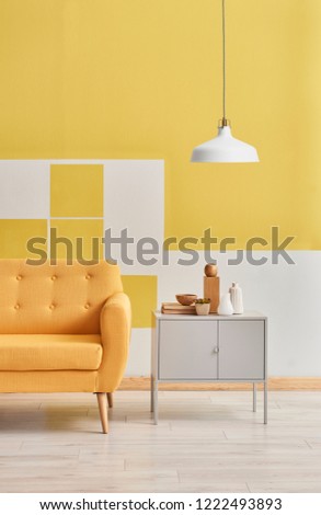 Yellow wall and sofa and grey cabinet room style. Yellow wall background and lamp style. Yellow room detail.