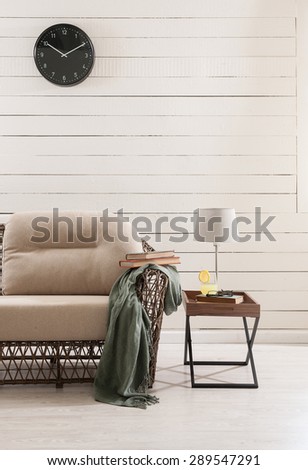 wooden wall and the wicker sofa with clock
