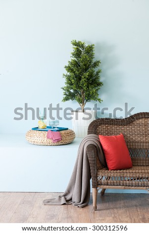 blue wall interior style with wicker sofa and lemonade