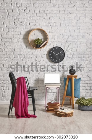 white brick wall interior style, laptop, black chair and clock