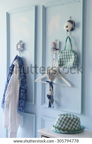 blue wall interior and clothes hangers with hat