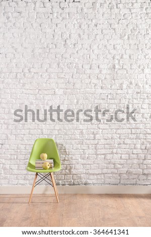 vertical white brick wall with modern green chair and green apple