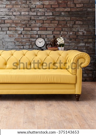 classic yellow sofa living room with brick wall and clock