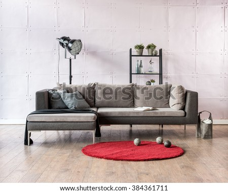 modern living room corner sofa behind stone soft wall and black lamp with red carpet