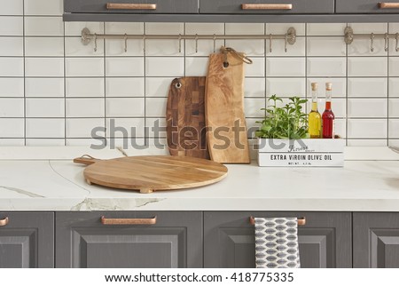 interior design of clean modern white and gray kitchen with copper equipment and chopping board