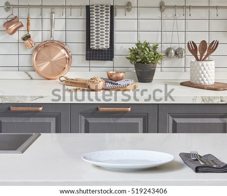 Background modern tiles wall, white table with modern kitchen accessories, interior design