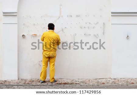 Electrician fixing electrical wiring on a white wall