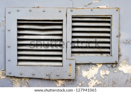 square windows with iron grating in a blue wall