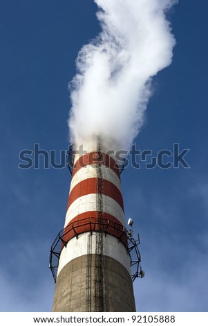 Factory pipe smoking with a white smoke over the blue sky