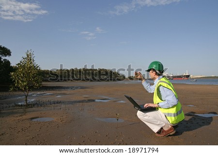Image of an ecologist taking samples next to a river