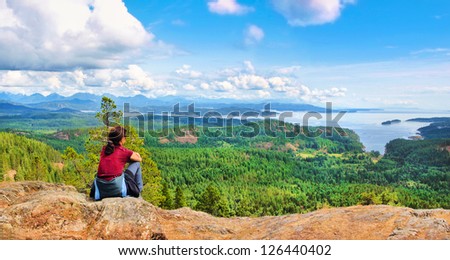 Woman Sitting On A Rock And Enjoying The Beautiful View On Vancouver Island, British Columbia, Canada