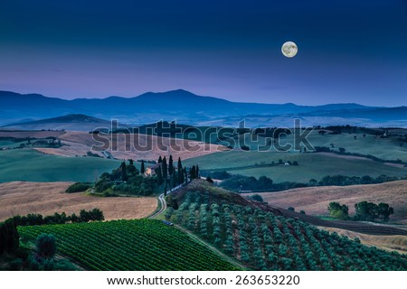 Panoramic view of scenic Tuscany landscape with rolling hills and valleys in beautiful moonlight at dawn, Val d\'Orcia, Italy