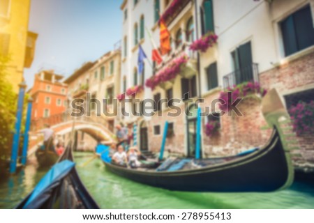 Abstract background blur bokeh image of traditional Gondolas on historic canal on a sunny day in Venice, Italy with pastel toned retro vintage Instagram style filter and lens flare effect
