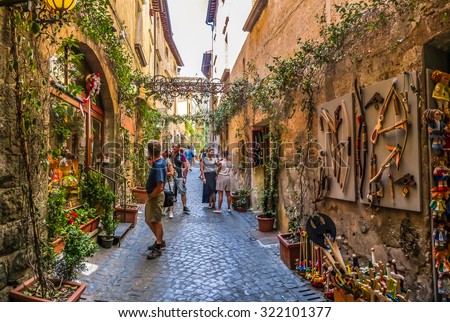 Beautiful view of frisky alley with ancient buildings at square near the Cathedral of Orvieto (Duomo di Orvieto), Umbria, Italy