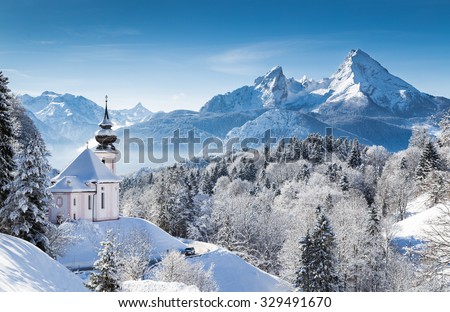 Panoramic view of beautiful winter wonderland mountain scenery in the Alps with pilgrimage church of Maria Gern and famous Watzmann summit in the background, Berchtesgadener Land, Bavaria, Germany