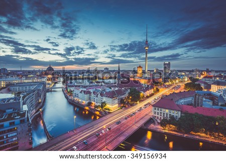 Aerial view of Berlin skyline with dramatic clouds in twilight during blue hour at dusk with retro vintage old Instagram style filter effect, Germany