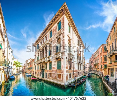 Typical romantic scene with traditional gondolas on channels between historic venetian buildings in Venice, Italy