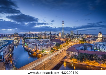Aerial view of Berlin skyline with famous TV tower and Spree river in twilight during blue hour at dusk with dramatic clouds, Germany