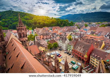 Aerial view of the historic city center of Freiburg im Breisgau from famous old Freiburger Minster in beautiful evening light at sunset with blue sky and clouds in summer, Baden-Wurttemberg, Germany