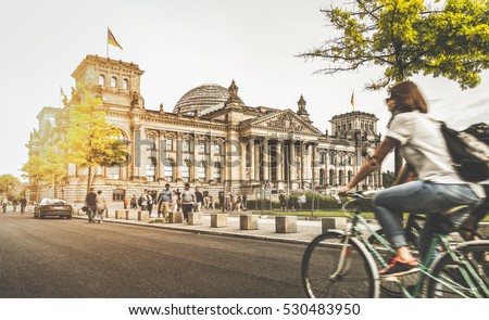 Berlin urban city life with famous Reichstag building in the background in beautiful golden evening light at sunset in summer with retro vintage Instagram style pastel toned filter effect, Germany