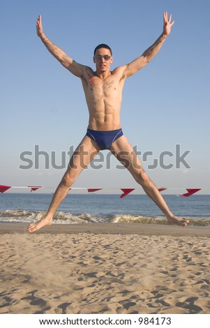 male model jumping on the beach