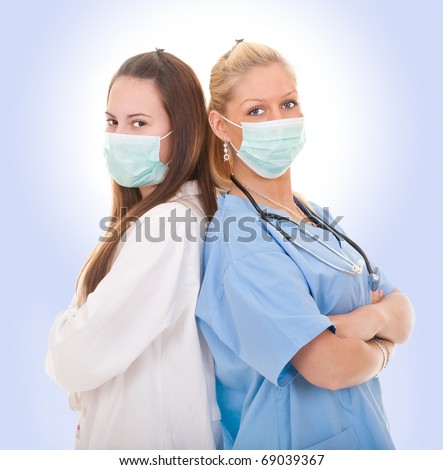 Two female doctors with masks isolate on white