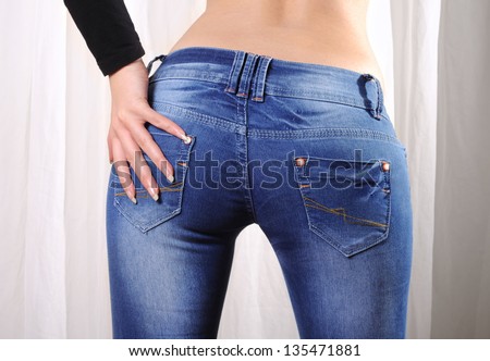 Sexy butt of a woman wearing tight skinny jeans, a hand on her butt.
