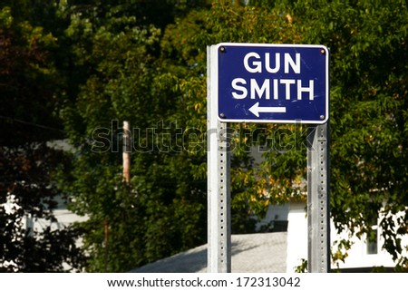 Gun Smith Sign. Sign pointing to the direction of a local gunsmith in a rural town.