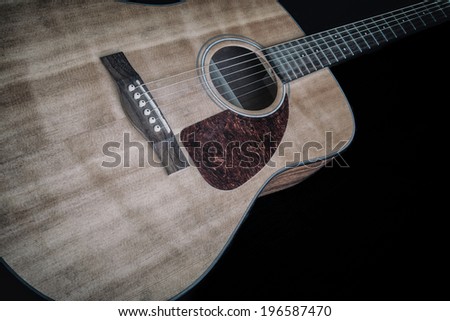 Acoustic Guitar on Black 1. An acoustic guitar against a black background.