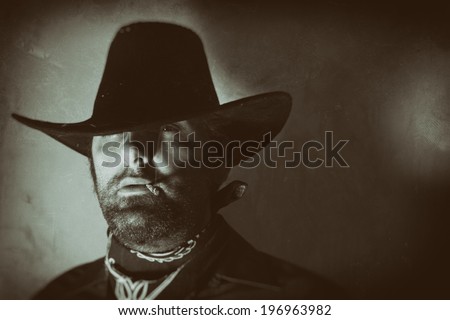 Old West Cowboy Smoker Eye. An old west cowboy smoking a hand rolled cigarette with one eye looking out, edited in vintage film style.