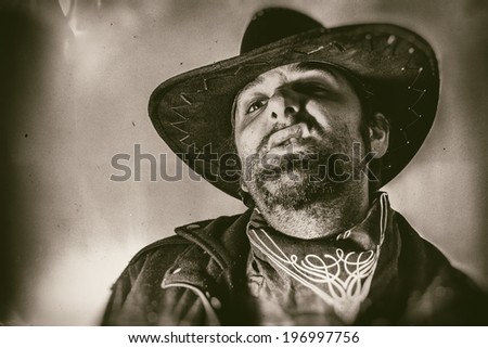 Old West Cowboy Snarl. Old west cowboy snarls in his cowboy hat,  edited in vintage film style.
