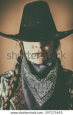 Old West Cowgirl Hat Low. Old west cowgirl with hat low blocking eyes, edited in vintage film style.