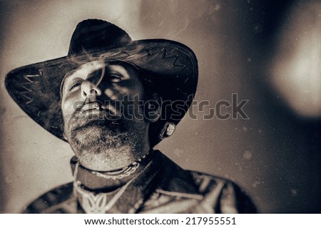 Old West Cowboy Smoke in the Eyes. An old west cowboy smoking a hand rolled cigarette, edited in vintage film style.