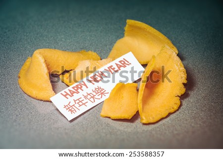 Fortune Cookie Happy New Year. A cracked open fortune cookie with the phrase, \