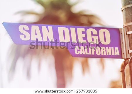 San Diego California Street Sign. A street sign marking San Diego, California. Backed by a palm tree with a sunset flare.