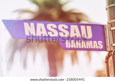 Nassau Bahamas Street Sign. A street sign marking Nassau, Bahamas. Backed by a palm tree with a sunset flare.