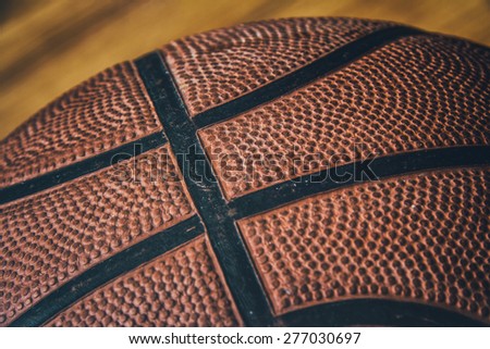 Basketball on Hardwood 4. Close-up of a basketball laying on the ground of a hardwood court in a gymnasium.