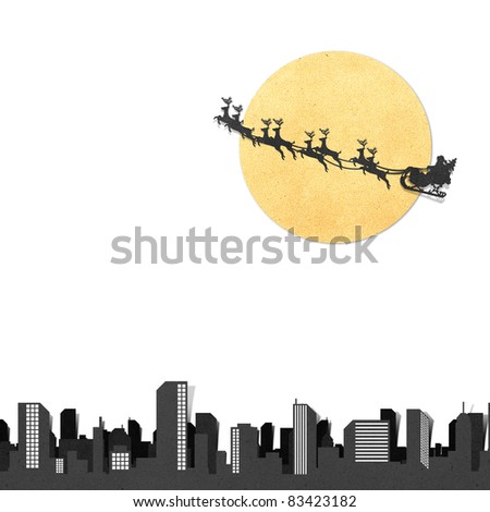 Santa Claus On Sledge With Deer And Moon above city panorama silhouettes  recycled papercraft  on white background