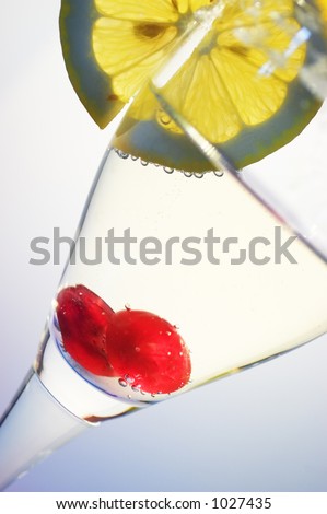 Glass of champagne with a cherry and a slice of lemon