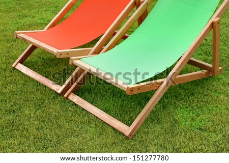 pair of lounge chairs standing on green grass