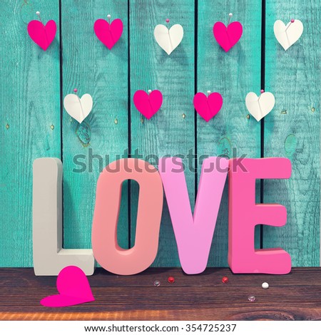 love letters and paper hearts on green wooden boards background