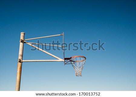 Side view of a basketball hoop against blue sky